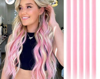 Könnte beinhalten: Eine Frau mit blondem Haar und rosa Strähnchen. Rechts sind fünf rosa Haarverlängerungen mit Clips. Die Frau trägt ein schwarzes Oberteil und eine Halskette. Die Haarverlängerungen haben eine einfarbige, leuchtende rosa Farbe.