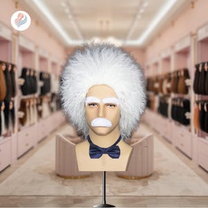 Puede incluir: Un busto de maniquí con peluca blanca, cejas y bigote, al estilo de Albert Einstein. Presenta una pajarita azul marino. Montado sobre un soporte negro, con un fondo borroso.