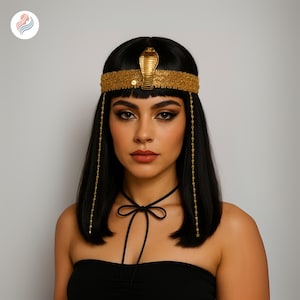 May include: A black wig with a gold headband and a cobra emblem. The headband is adorned with intricate gold detailing. Gold beaded strands hang from the headband. The model is wearing a black top and a black choker.