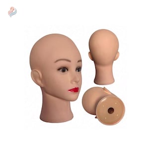 Può includere: Una testa di manichino con un'espressione neutra, dipinta con tonalità della pelle realistiche e rossetto rosso. La testa è calva e ha una superficie liscia in plastica. Il manichino è mostrato da tre angolazioni diverse.