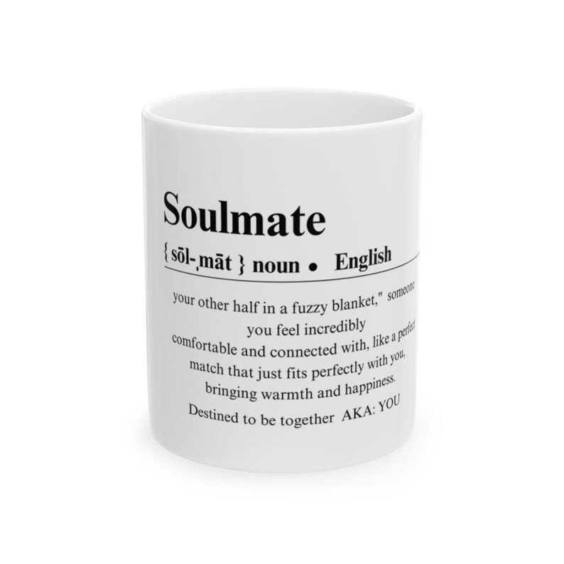 May include: White ceramic mug with black text that reads "Soulmate {sol-māt} noun &bull; English your other half in a fuzzy blanket, someone you feel incredibly comfortable and connected with, like a perfect match that just fits perfectly with you, bringing warmth and happiness. Destined to be together AKA: YOU"