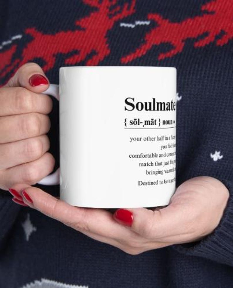 May include: White ceramic mug with a black definition of the word "Soulmate" printed on it. The definition reads: "{sol-mat} noun your other half in a relationship, you feel comfortable and connected, a match that just fits, bringing warmth. Destined to be together."