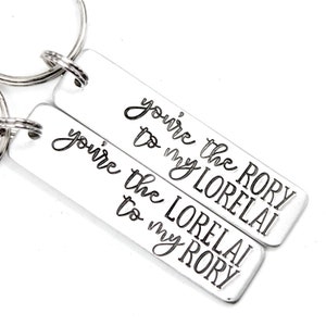 May include: Two silver keychains with the text "You're the Rory to my Lorelai" and "You're the Lorelai to my Rory" engraved on them.