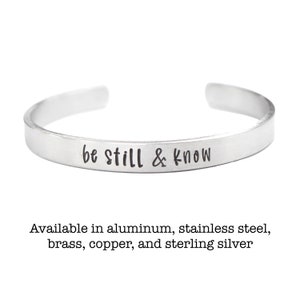 May include: Silver bracelet with the inscription "be still & know".