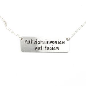 May include: Silver necklace with a rectangular pendant that reads "Aut viam inveniam aut faciam".