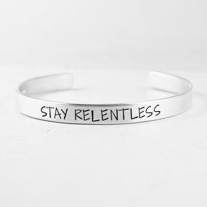 Op de afbeelding: Een set van drie keramische mokken met een gespikkelde, matte afwerking. De mokken zijn in tinten crème, lichtgrijs en donkergrijs. Elke mok heeft een eenvoudig, minimalistisch ontwerp en een afgeronde handgreep. De mokken zijn op elkaar gestapeld.