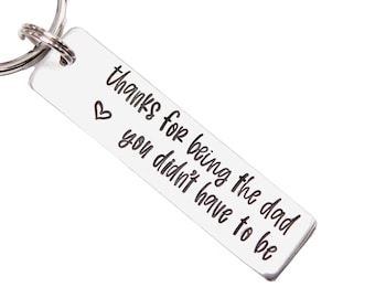 May include: Silver keychain with a heart and the text "thanks for being the dad you didn't have to be".