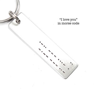 May include: Silver keychain with the phrase "I love you" in Morse code.