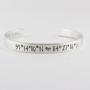 May include: Silver bracelet with the coordinates 39°14'10"N ♥ 84°27'16"W engraved on it.