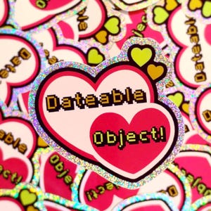 Puede incluir: Una colección de pegatinas en forma de corazón con un borde holográfico brillante. Cada pegatina presenta el texto "Dateable Object!" en una fuente pixelada, con un corazón rosa en el centro y pequeños corazones amarillos.
