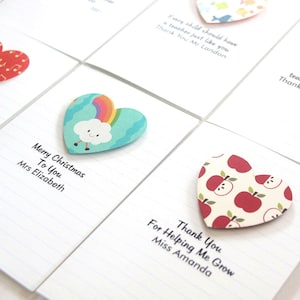 May include: A set of six heart-shaped cards with different designs and messages. The cards are printed with lined paper and have a white background. The messages include "Merry Christmas to You", "Thank You", "For Helping Me Grow", and "Every child should have a teacher just like you".