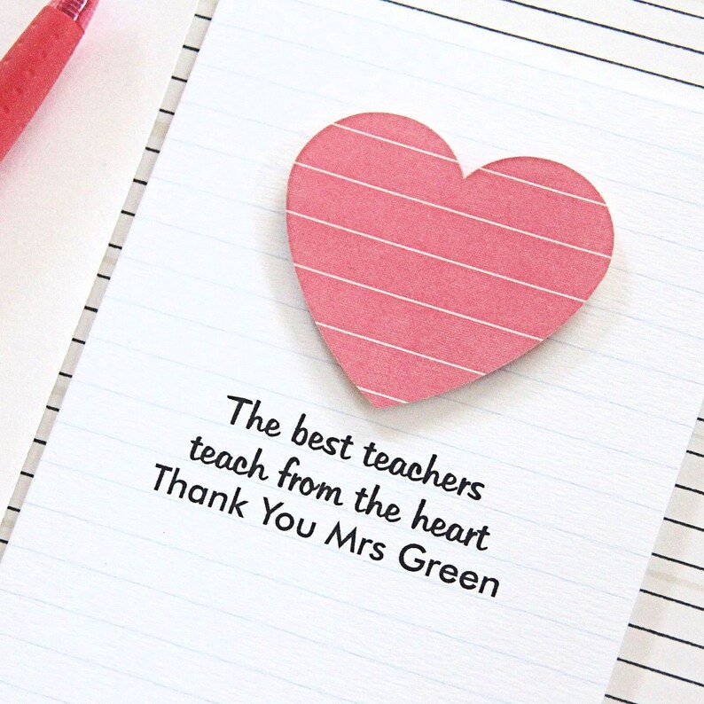 May include: A pink heart-shaped sticky note with white stripes on a lined white paper background. The text on the paper reads: "The best teachers teach from the heart. Thank You Mrs Green."
