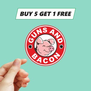 Può includere: Un adesivo rotondo rosso con le parole "GUNS AND BACON" che circondano un'illustrazione di maiale sorridente. L'adesivo include anche il testo "BUY 5 GET 1 FREE" in un banner bianco, su sfondo turchese.