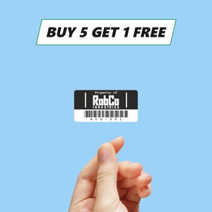 May include: A black and white tag with the text "Property of RobbCo Industries" and the code "RCO-0001". The tag is floating in the air above a hand making a pinching gesture. The background is light blue and the text "BUY 5 GET 1 FREE" is at the top of the image.