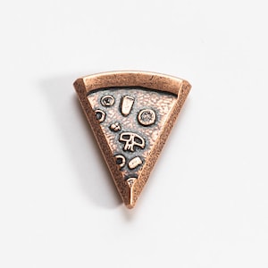 Pode incluir: Um pequeno amuleto de metal de cor cobre em forma de fatia de pizza com um design detalhado de pepperoni, cogumelos e queijo.