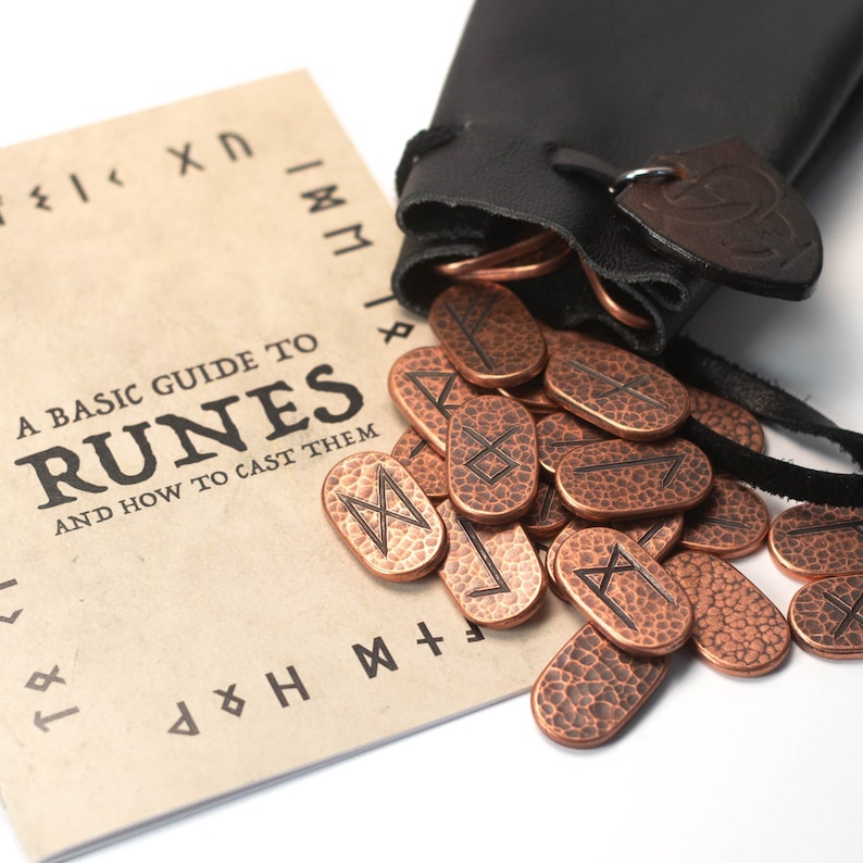 May include: A basic guide to runes and how to cast them, with a leather pouch containing copper runes. The runes are oval-shaped with etched symbols.