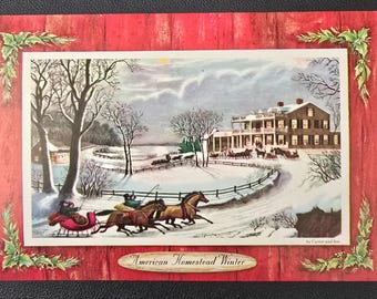 May include: A vintage winter scene postcard with a red wooden frame and holly accents. The central image depicts a snowy landscape with a large house, horse-drawn carriages, and the text "American Homestead Winter."