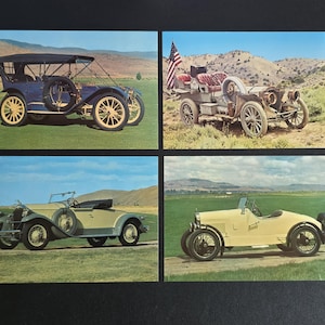May include: Four vintage car postcards. The top left shows a blue car with a black top and yellow wheels. The top right shows a vintage car with an American flag. The bottom left shows a light green car. The bottom right shows a yellow car.