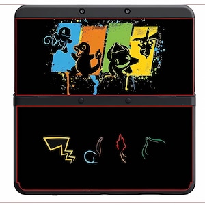 May include: Black Nintendo 3DS console skin with a colourful design featuring cartoon characters. The top panel shows four characters over blue, orange, green, and yellow paint splatters. The bottom panel has four character outlines.