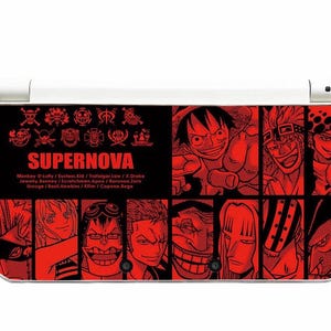 May include: A black and red Nintendo 3DS featuring a graphic design with the word "SUPERNOVA" and various anime character illustrations. The design includes the names of the characters. The 3DS is white.