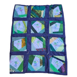 May include: A patchwork quilt with a blue background and green squares. Each square features a different design of a frog in a green, blue, and white color scheme.