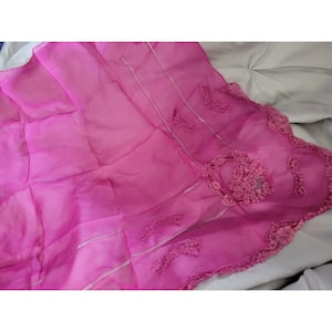 May include: A vibrant hot pink sheer fabric scarf featuring delicate tonal lace appliques along the edges and scattered across the surface. The lightweight material has a semi-transparent quality with visible vertical stitching lines throughout the design.
