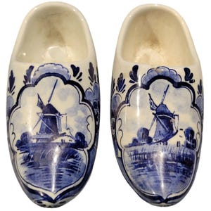 May include: Pair of blue and white ceramic Dutch shoe salt and pepper shakers. Each shoe features a windmill scene.