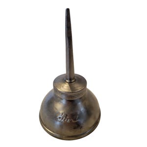 May include: A vintage silver-toned oil can with a long, slender spout and a rounded body. The can has a screw-on cap and a small, embossed design on the side. The spout is approximately 4 inches long.