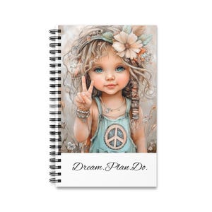 Op de afbeelding: Spiraalgebonden notitieboek met een illustratie van een jong meisje met blauwe ogen, een bloemenkrans en een vredesteken op haar outfit. Het notitieboek heeft de tekst "Dream. Plan. Do."
