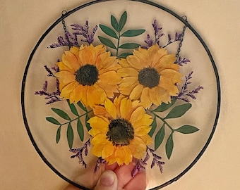 Geperste zonnebloemkunst: glas-in-loodraam aan de muur