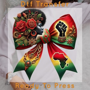 May include: A colorful DTF transfer design featuring a bow with a Black woman's profile, roses, and a raised fist. The bow has red, green, and yellow stripes, with the African continent's outline. Text at the top reads "Dtf Transfer" and at the bottom "Ready To Press."