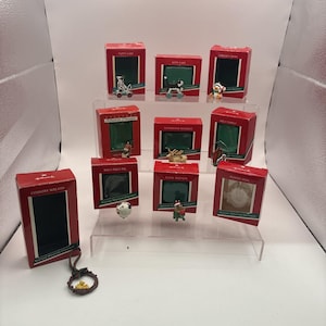 May include: A collection of ten Hallmark Keepsake miniature ornaments in individual red boxes. The set includes various figures like a puppy, kitten, reindeer, and a country wreath, each displayed with its corresponding packaging.