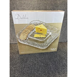 May include: A square Dublin Crystal cheese and cracker server in a cardboard box. The clear glass tray features a faceted diamond pattern and a central raised section. The box displays the text Dublin Crystal and Shannon Crystal.