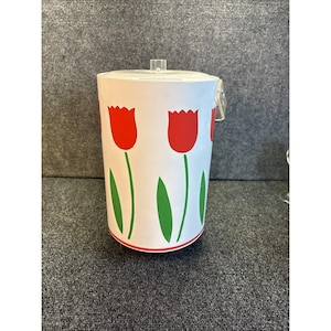 以下が含まれることがあります： 赤いチューリップのデザインが施された白いアイスバケツ。バケツには透明なプラスチック製のハンドルと蓋が付いています。チューリップは緑色の茎と葉を持っています。バケツの底には赤いストライプがあります。