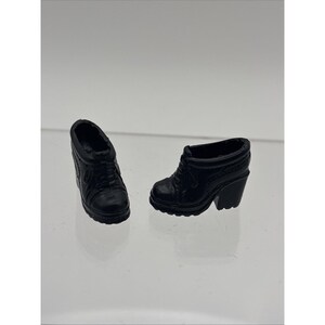 May include: Two black ankle boots with laces and block heels. The boots are made of a textured material and have a classic design. The heels are approximately 2 inches high.