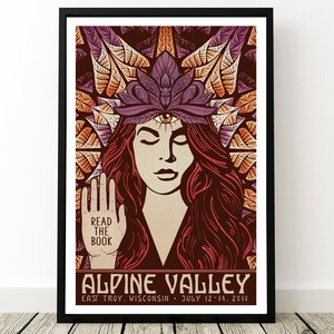 May include: A vintage-style poster with a woman with long red hair and a third eye. The woman is wearing a purple flower crown and has her hands raised. The poster says "Read the Book" and "Alpine Valley" with the dates "July 12-14, 2019".