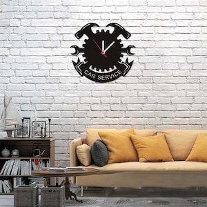 May include: Black metal wall clock with a gear design and wrench accents. The clock face reads "Car Service".