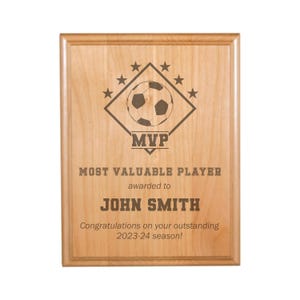 May include: A wooden plaque with a soccer ball graphic and the text "MVP Most Valuable Player awarded to John Smith Congratulations on your outstanding 2023-24 season!"