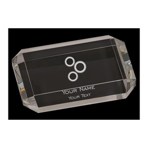 May include: A rectangular clear crystal award with beveled edges. The award has a black interior with three white gear icons and the text "YOUR NAME" and "YOUR TEXT" in white.