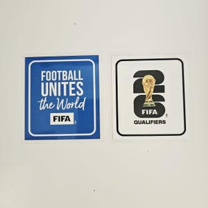 Pode incluir: Uma caneca de cerâmica branca com uma alça preta e o texto "But First, Coffee" em estilo manuscrito. A caneca está sobre uma superfície branca. A caneca tem aproximadamente 10 cm de altura.