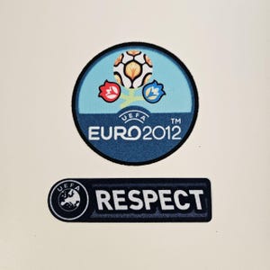 May include: Two patches featuring the UEFA EURO 2012 logo and the word "RESPECT". The EURO 2012 patch is circular with a light blue background, a soccer ball, and three stylized flowers. The "RESPECT" patch is rectangular with the UEFA logo.