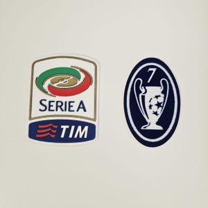 Puede incluir: Dos parches bordados. Uno es un parche de la Serie A con el texto "SERIE A" y "TIM". El otro es un parche azul oscuro con un trofeo de la Liga de Campeones blanco y el número "7".