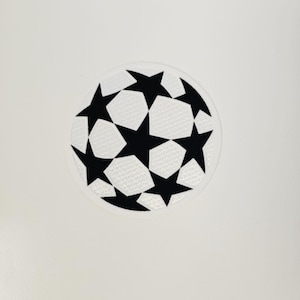 Könnte beinhalten: Runder Aufnäher mit einem Fußball-Design. Der Ball besteht aus schwarzen Sternformen und weißen Fünfecken, vor einem weißen Hintergrund. Geeignet für Kleidung oder Accessoires.