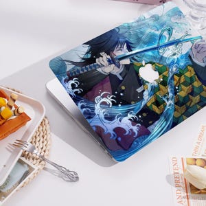 Puede incluir: Funda para portátil con una vibrante ilustración de anime. El diseño muestra un personaje con una espada, rodeado de patrones dinámicos de olas de agua en tonos azules y blancos. La funda cubre la superficie superior del portátil.