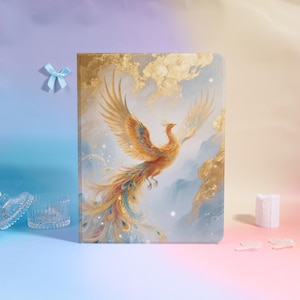 Può includere: Un diario rettangolare con un'illustrazione di fenice. La copertina presenta una fenice vibrante con le ali spiegate, in tonalità oro, arancione e blu, su uno sfondo di cielo nuvoloso con accenti dorati. Il diario è un oggetto decorativo.