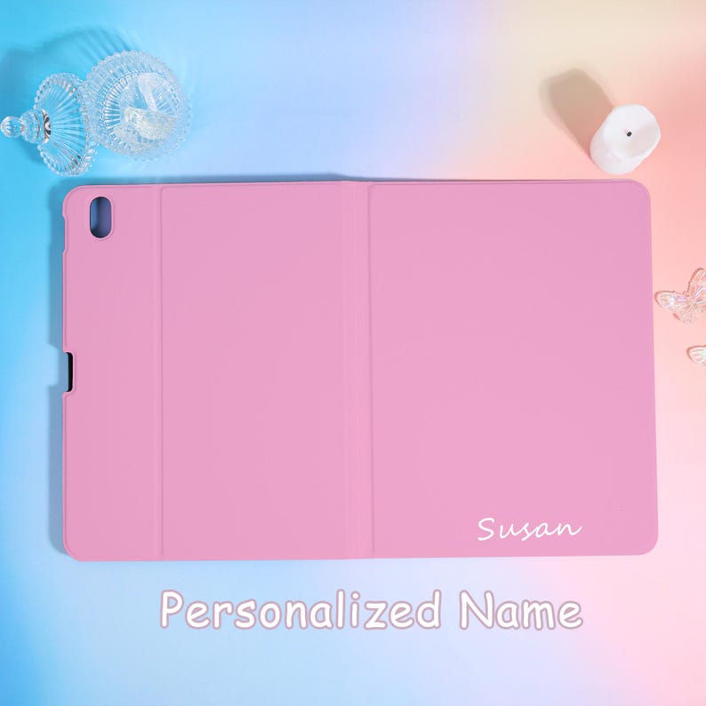 Pode incluir: Uma capa de tablet rosa com o nome "Susan" em escrita branca. A capa est&aacute; fechada e tem uma superf&iacute;cie lisa. As palavras "Personalized Name" est&atilde;o na parte inferior da imagem.