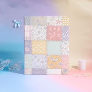 May include: A rectangular notebook featuring a patchwork design of various pastel-coloured squares. The patterns include floral prints, polka dots, grid lines, and paisley motifs in shades of pink, yellow, blue, and lavender with scalloped edges.