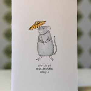 May include: A white greeting card with a detailed illustration of a gray mouse holding a yellow parasol. The card has text in Swedish that reads "grattis på födelsedagen, kompis".