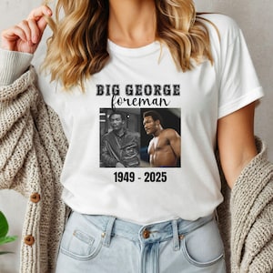 May include: White t-shirt with a black graphic that says "BIG GEORGE foreman" with two photos of George Foreman and the dates "1949 - 2025".