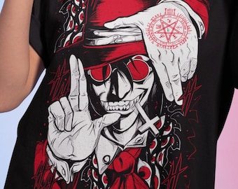May include: Black t-shirt featuring a stylized illustration of a character with a top hat, sunglasses, and a cross. The design includes red accents and a hand with a pentagram tattoo. The person in the image is wearing gold hoop earrings and a red watch.